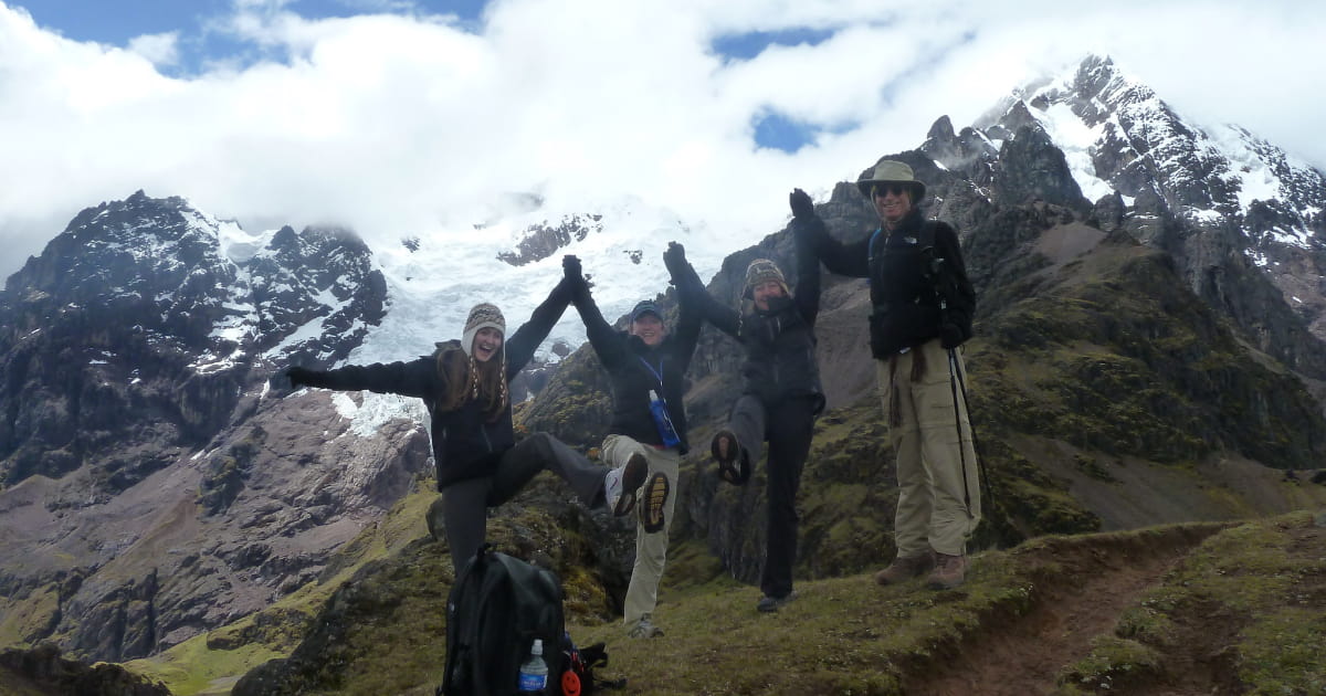 Group of 4 hikers in front of a snow capped mountain on the lares trek