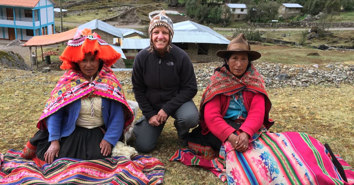 a traveler sitting beside 2 local villagers in a small remote village