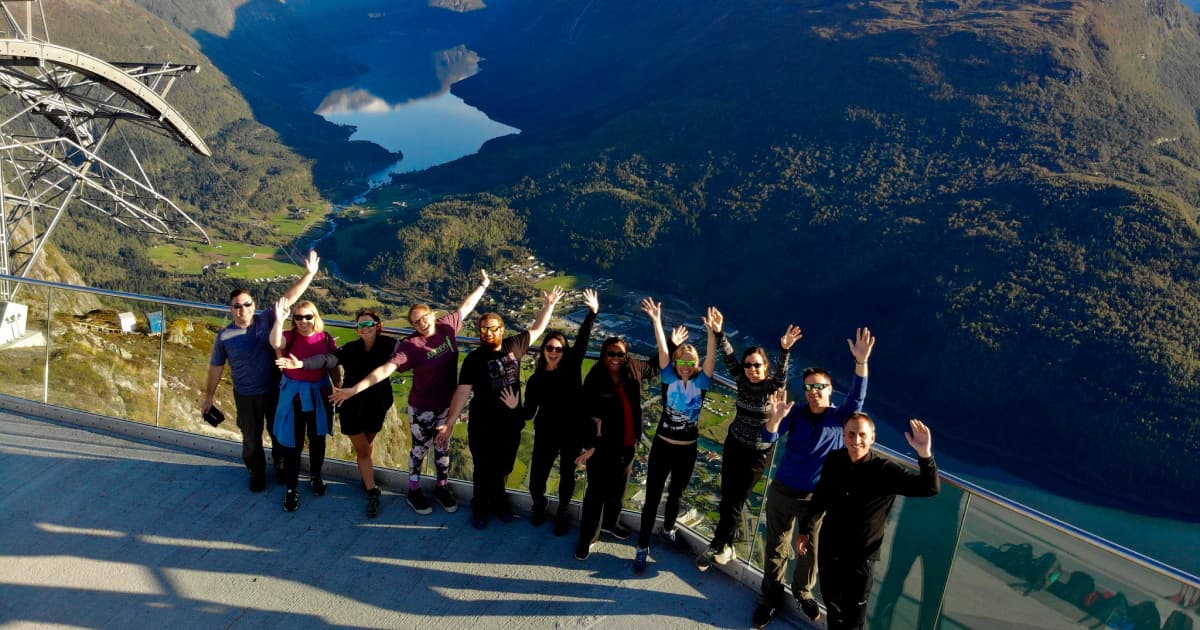 group of travelers celebrating the end of a hike overlooking a scenic landscape