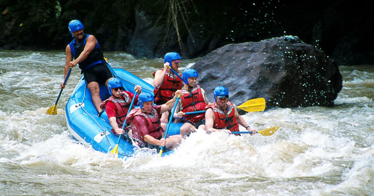 a raft full of adventure travelers navigating the water rapids of the pacuare river