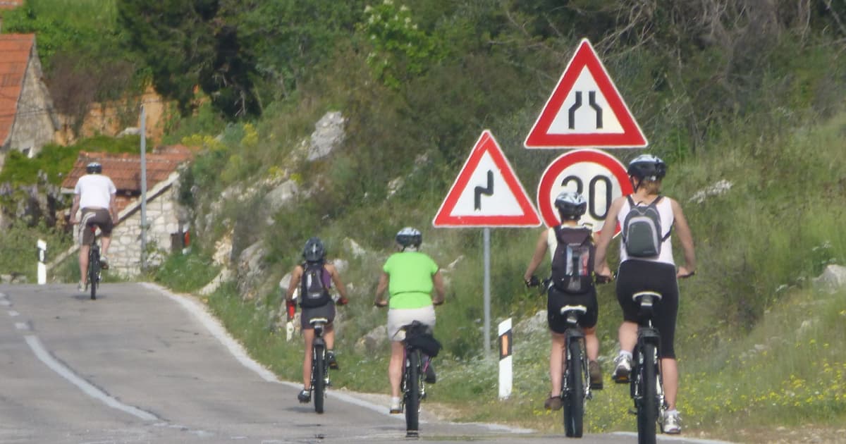a group of cyclists on a winding road in Croatia