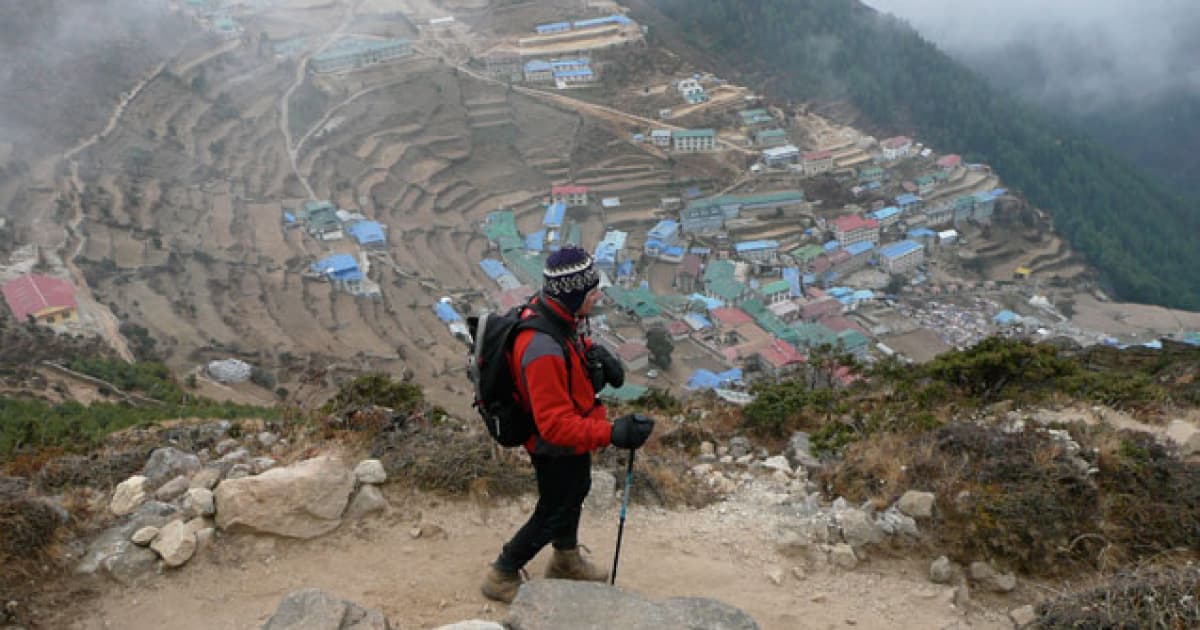 Traveler on a mountain overlooking small village