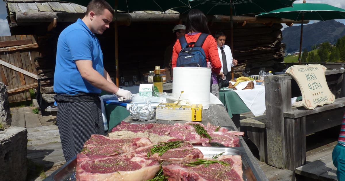 a chef cooking steak outdoors