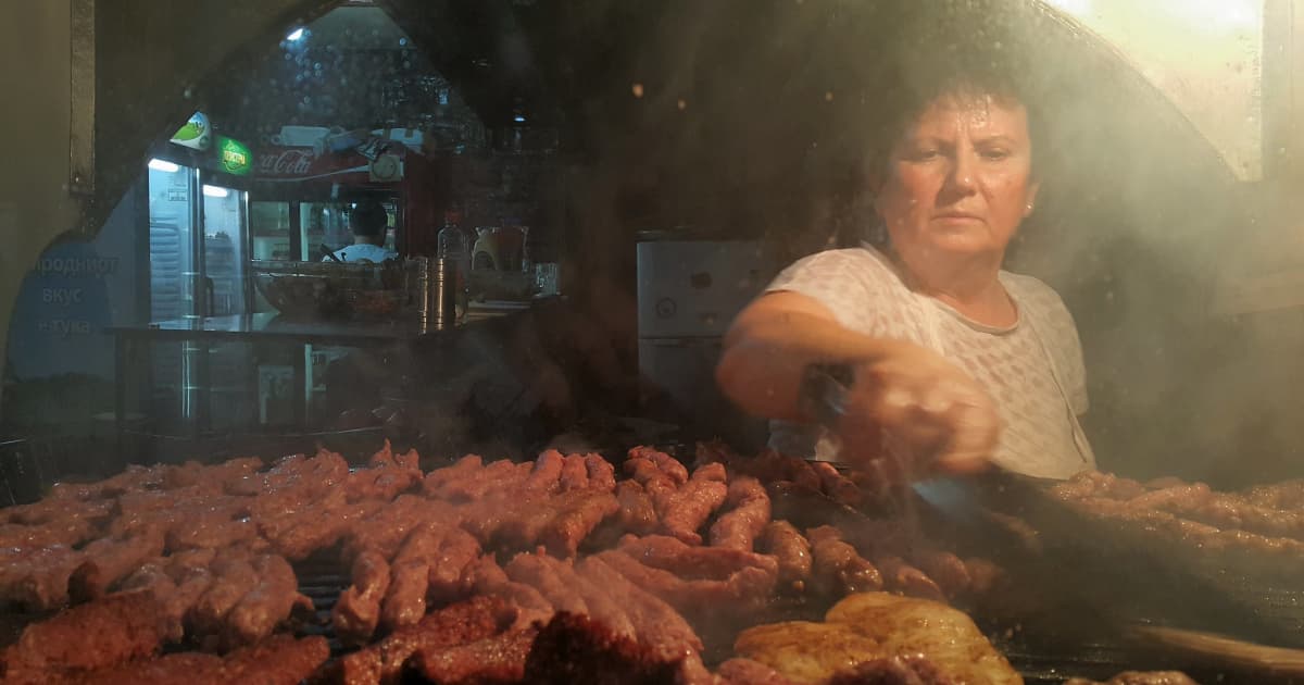 a cook preparing a meat selection on a grill