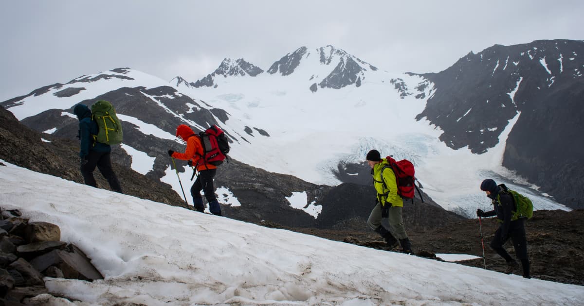 Travelers trekking up a steep slope on a snowy mountain