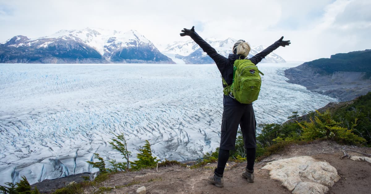 A trekker overlooking a snowcapped landscape in Patagonia