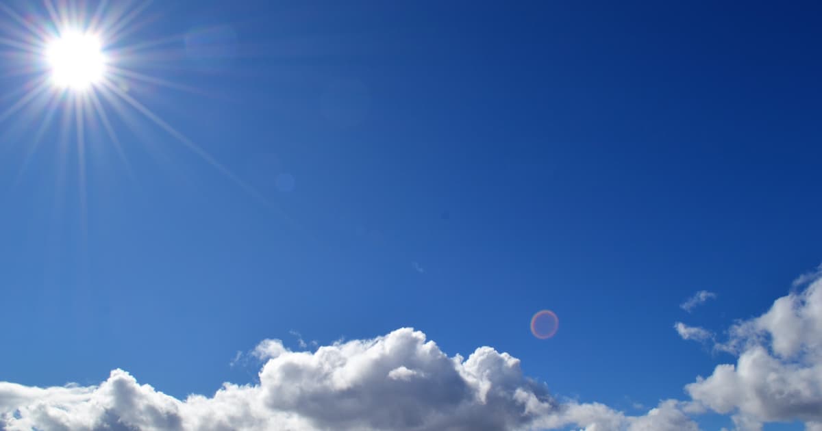 the sun over clouds on a clear day with a blue sky