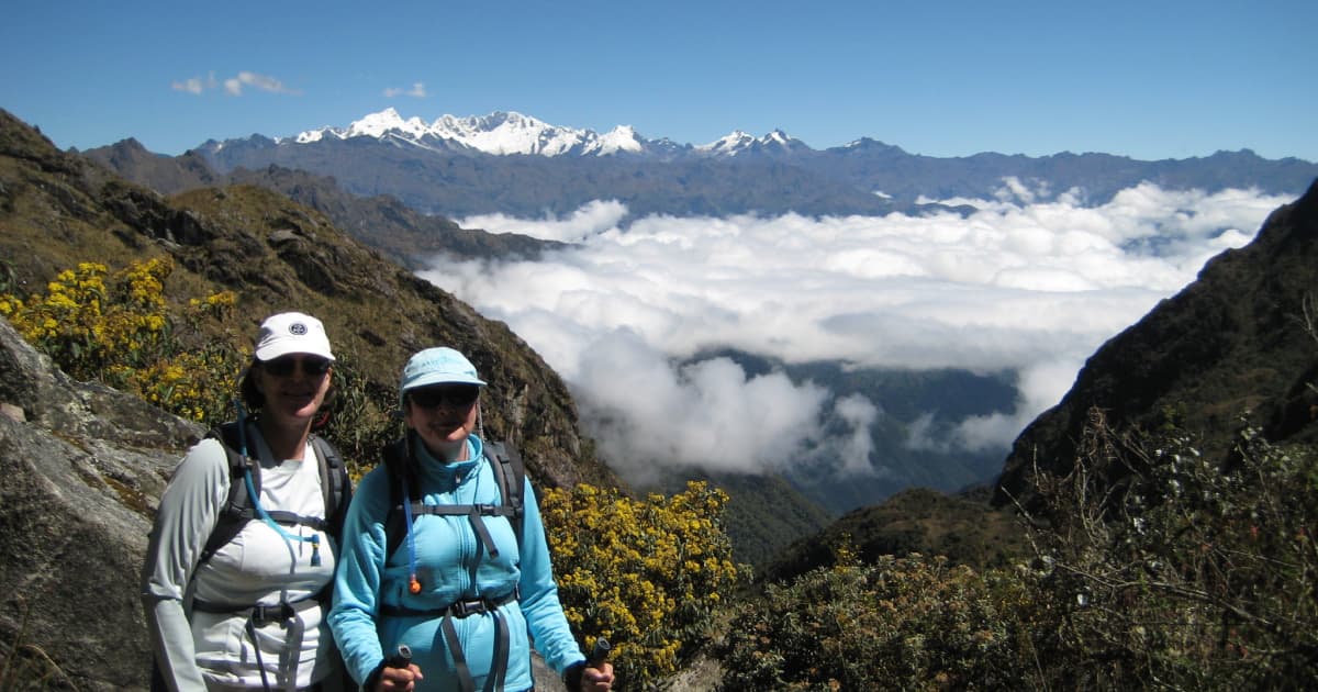 2 travelers posing on the Inca trail in front of a mountain backdrop