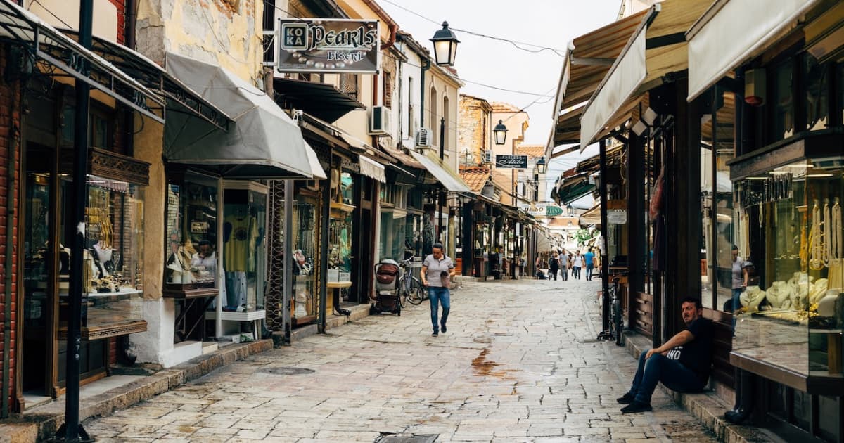 tourists and locals walking an old cobbled street in Skopje