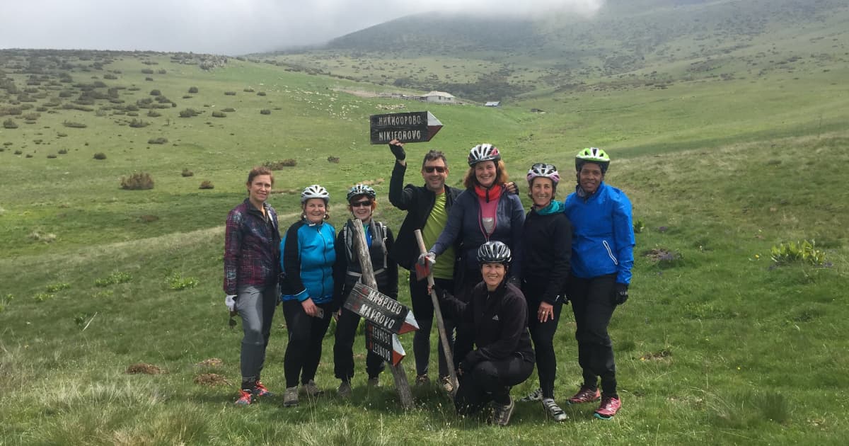 a group of bikehike travelers celebrating the end of a hike in the middle of a field at north macedonia