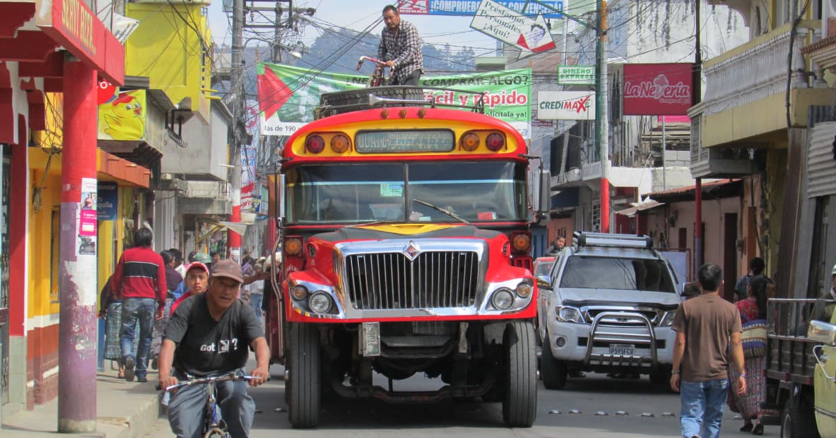 tourists and villagers traveling down a busy dirt road