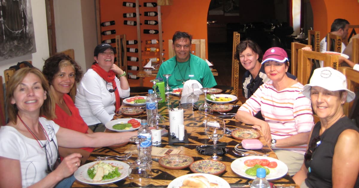 a group of travelers at a table in Peru waiting on a meal