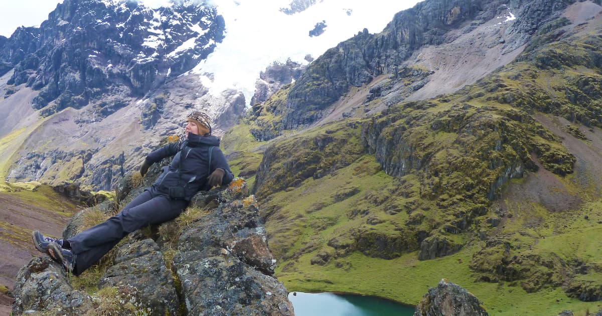 a hiker resting on a rock on a hiking trail