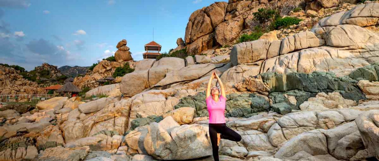 Traveler doing Yoga on a rock