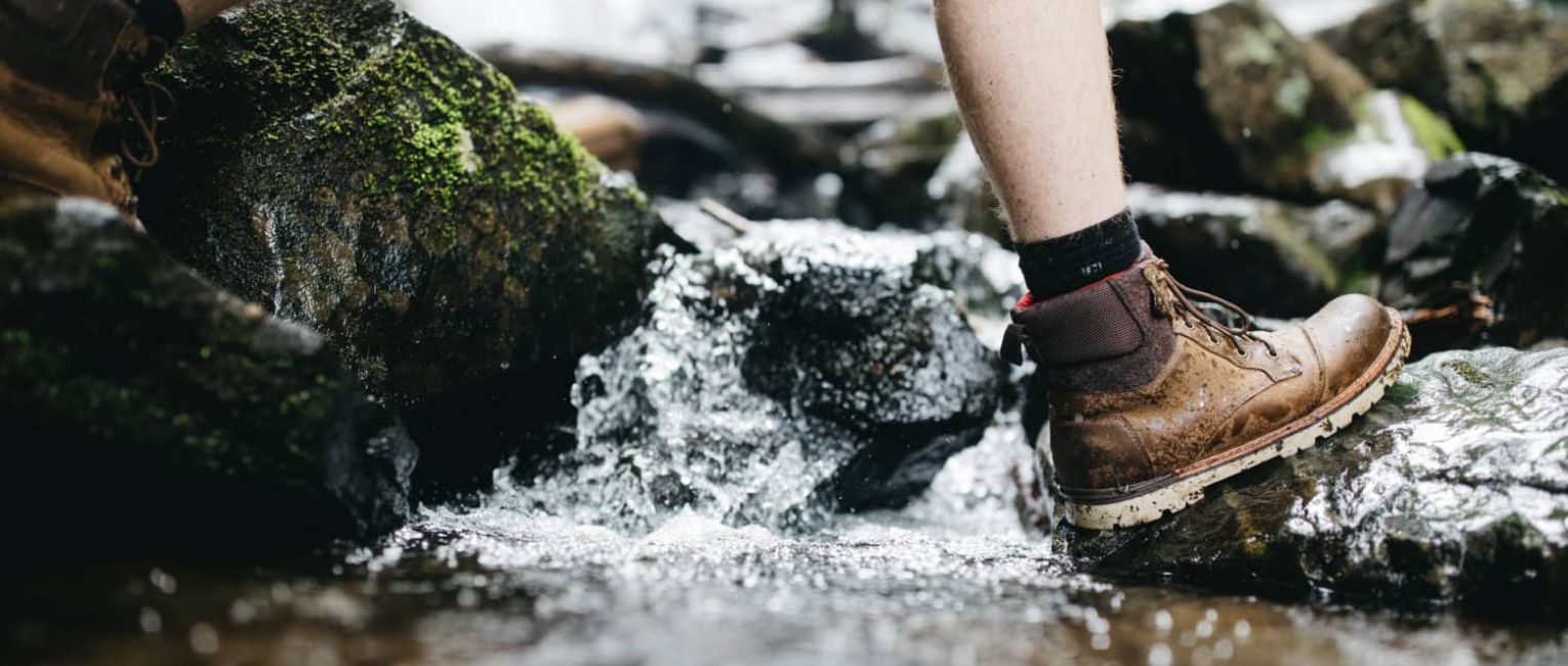 hiker walking through shallow lake