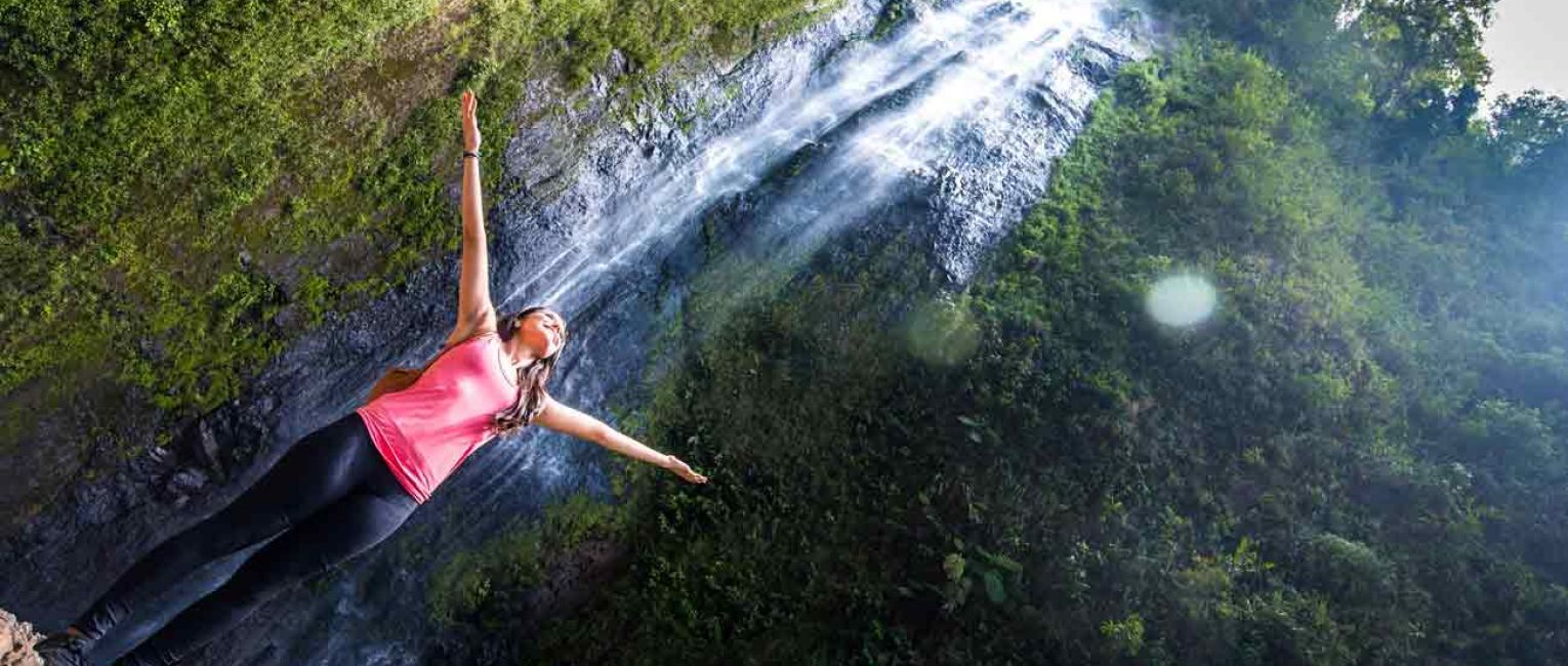 Traveler standing under Nicaragua waterfall